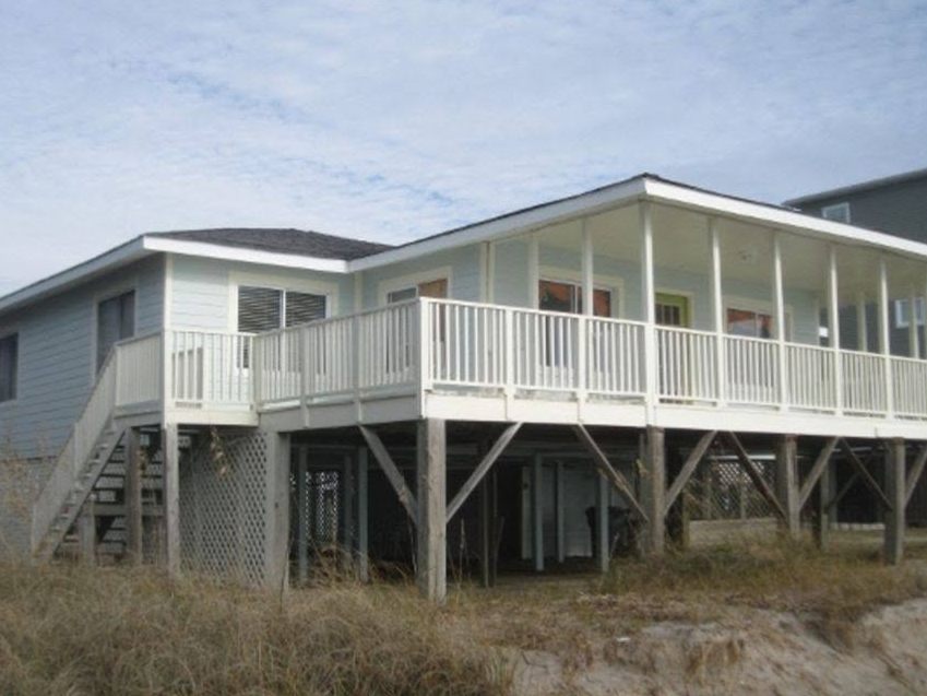 White raised beach cottage with a long porch on pilings on Edisto Island