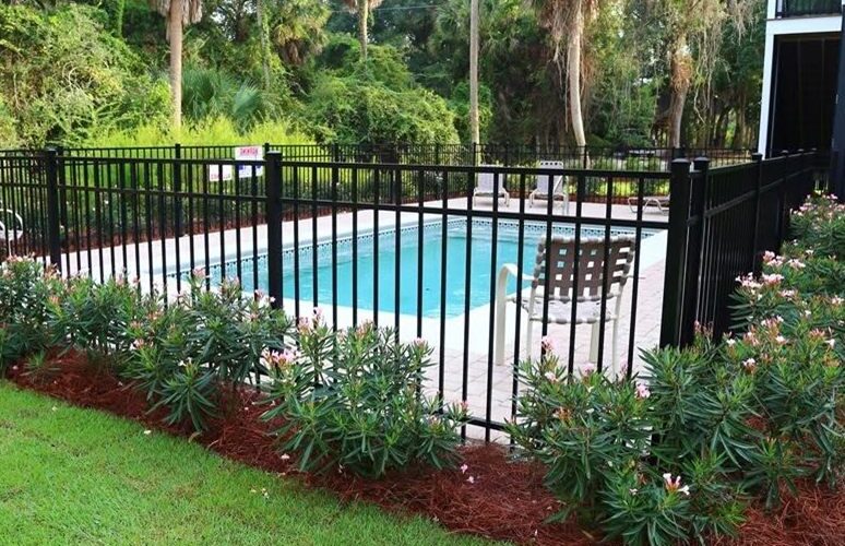 Fenced private pool with flowering shrubs at an Edisto Island rental home