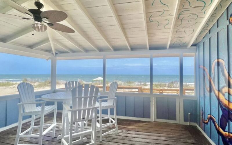 Screened porch with an ocean view and a painted mural at an Edisto rental