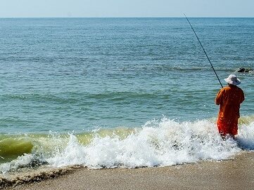 Angler surf fishing in the waves on Edisto