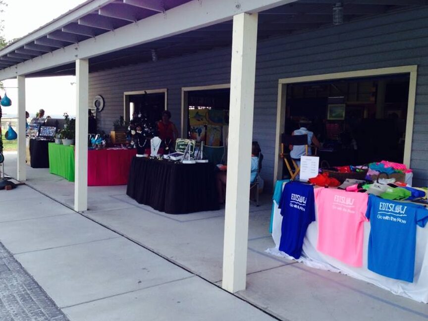 Vendor tables set up under a covered pavilion at the Bay Creek Park market on Edisto
